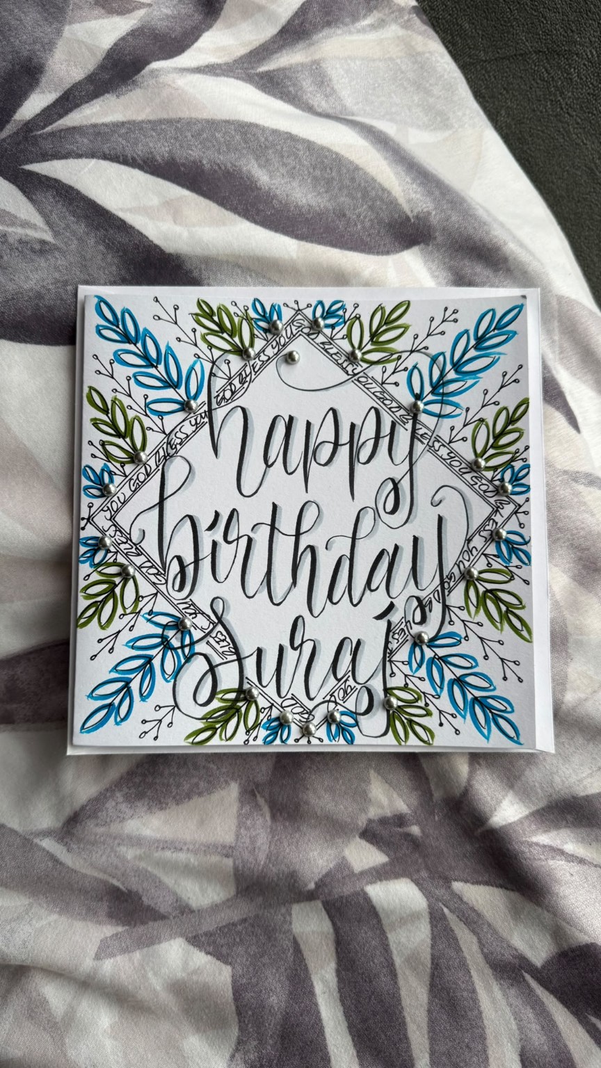 Hand-lettered personalised birthday card with blue and green botanical details.